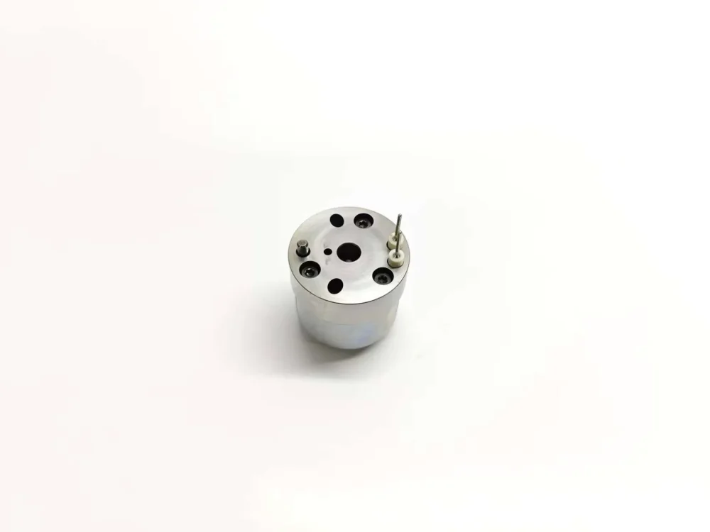Top-down angled view of E1 electronic fuel unit injector control valve 7206-0379 showing the flat polished top surface layout, terminal pin holes, fluid ports, and anchoring pin configurations.