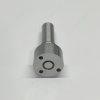 dlw-nozzle-nz7006-l322pbc-inlet-pins Macro shot of DLW NZ7006 nozzle bottom surface showing mating pin holes and fuel inlet port.